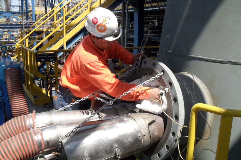 industrial technician monitoring refinery furnace heat curve